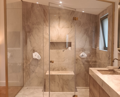 paroi de douche en angle en verre et laiton