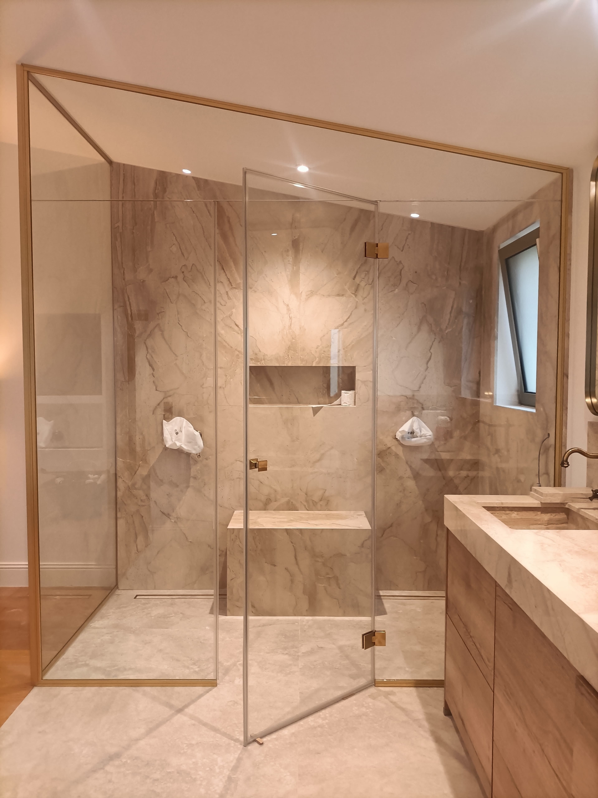 paroi de douche en angle en verre et laiton