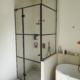 Installation de parois de douche en verre sur-mesure style atelier avec profils noirs dans un hôtel particulier à Nice.
